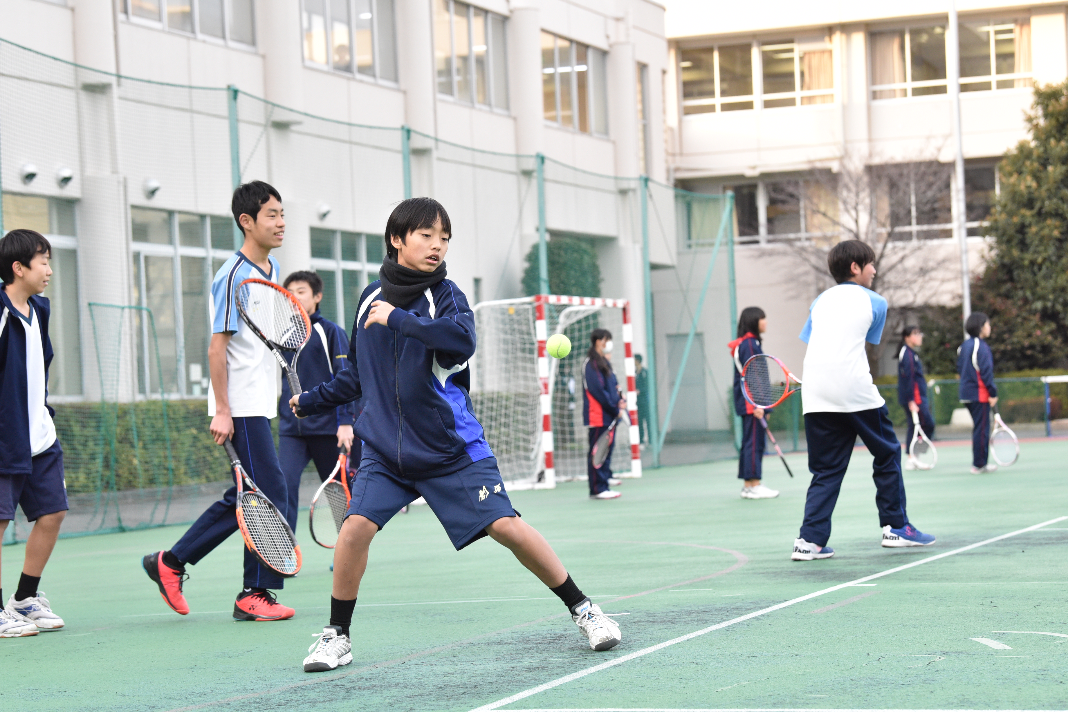 テニスをする男子生徒